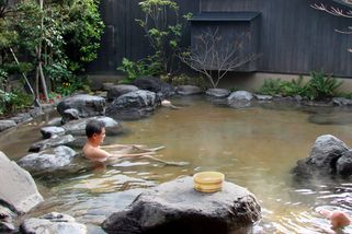 Człowiek odpoczywający w Onsen (japońska łaźnia termalna)